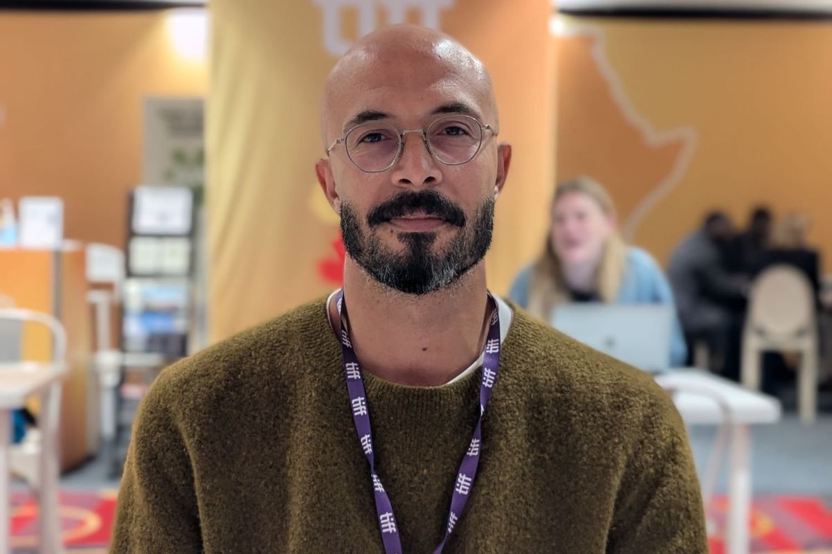 A portrait photo of Muhammed Hamdy in a green sweater at the Toronto International Film Festival (TIFF)
