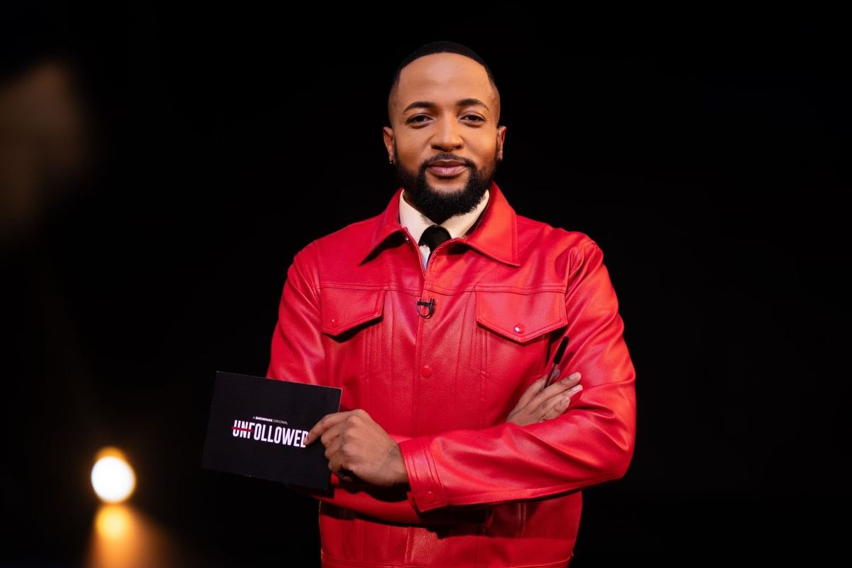 A still from Unfollowed of a man in a bright red leather jacket holding a card.