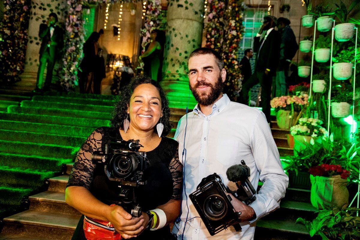Filmmakers Maia Lekow and Christopher King with cameras outside the McMillan Memorial Library during its annual gala.