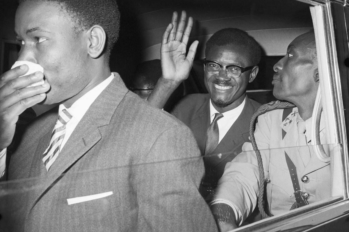 Former Congolese Premier Patrice Lumumba flashes a big smile and waves as he leaves Idlewild Airport for Manhattan, following his arrival in New York on July 24, 1960.