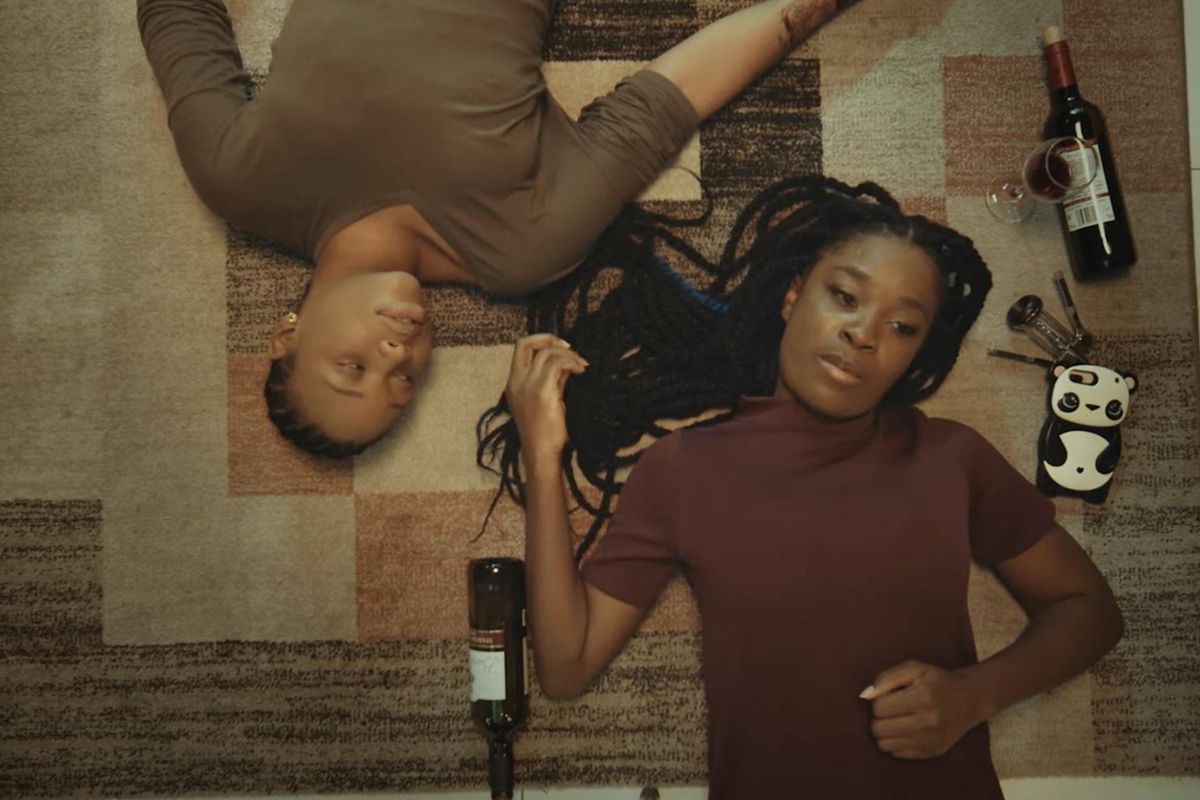 Ìfé women laying with win bottle
