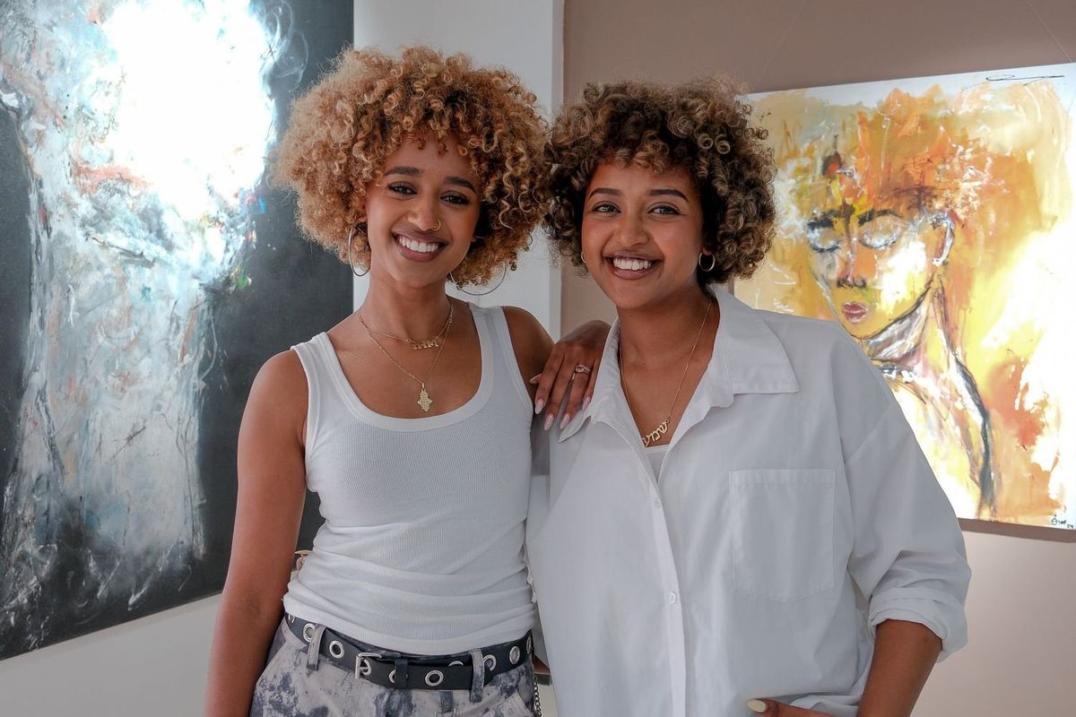 Nafkot Gebeyehu and Zion Yaynu, co-founders of Studio 11, standing together in front of colorful artwork at their gallery in Addis Ababa, Ethiopia. 