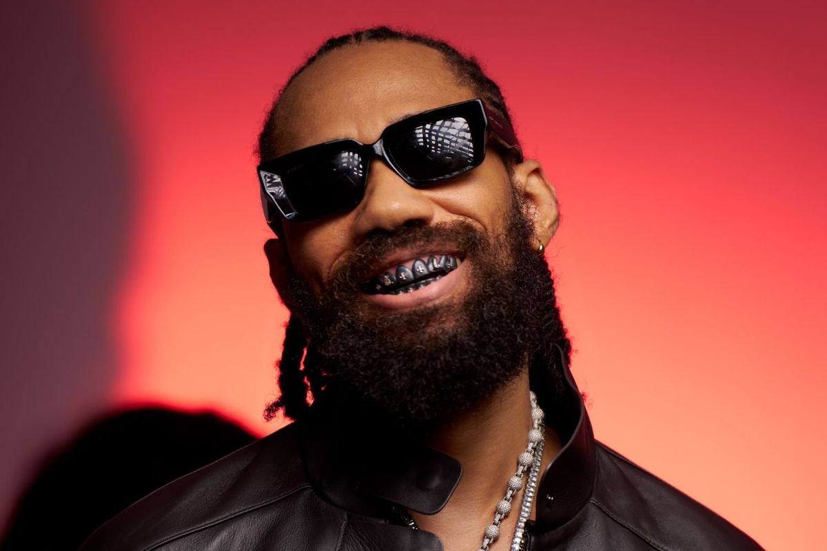Nigerian rapper Phyno smiles while wearing dark sunglasses,  showing grills in his teeth. 