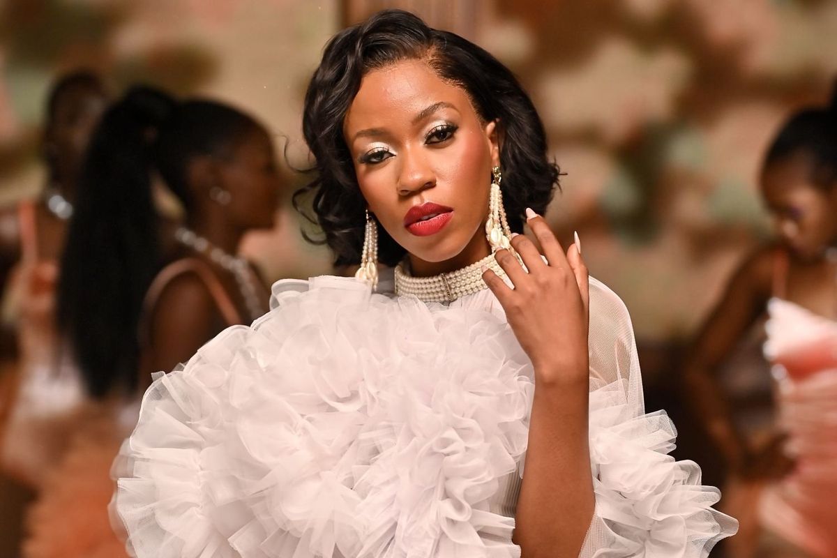 Ugandan artist Vinka in a white ruffled crop top with pearl-adorned shorts.