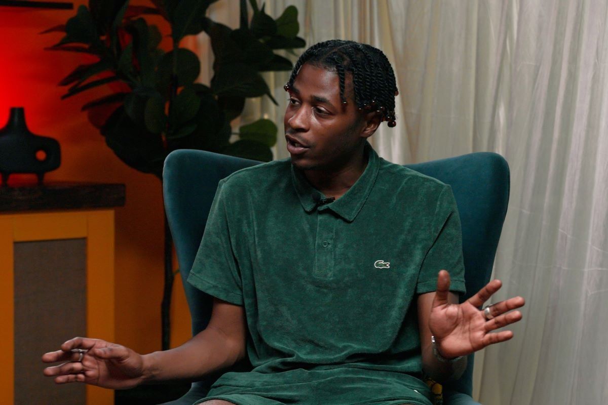 Yame sits in a chair at the OkayAfrica studio. 